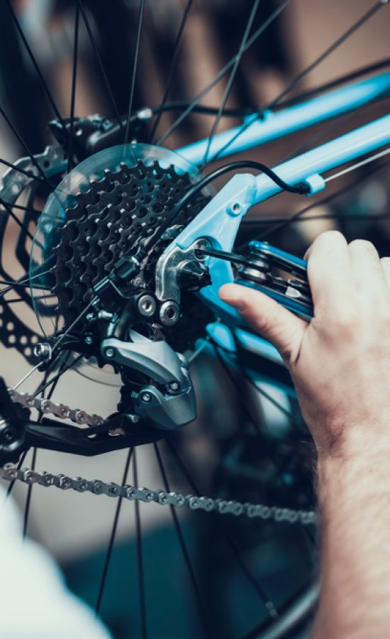 Mechanic adjusting the rear derailleur on a bike in the workshop